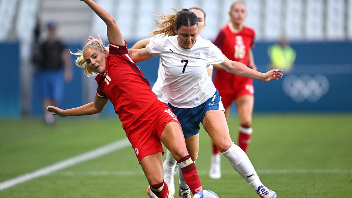 Two soccer athletes contest for the ball.