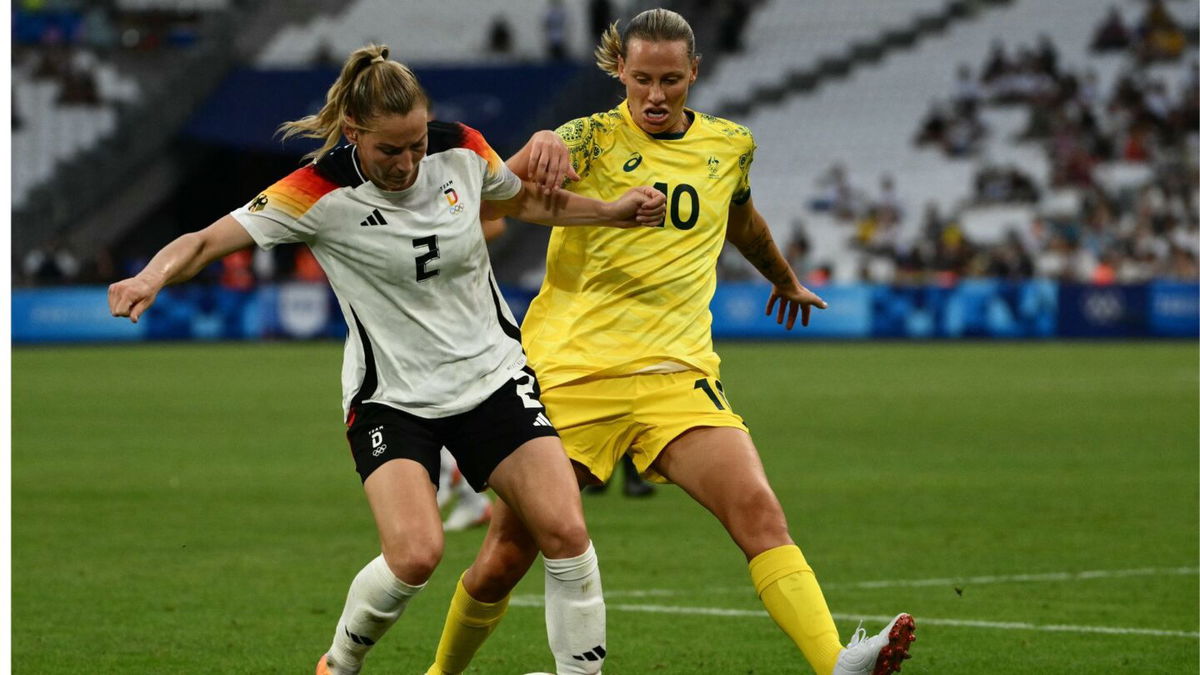 Two soccer athletes contest for the ball.