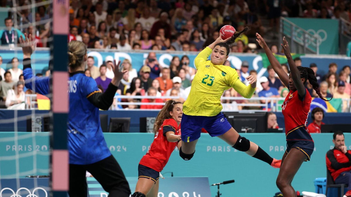 Brazil player attempts to take a shot during handball match.