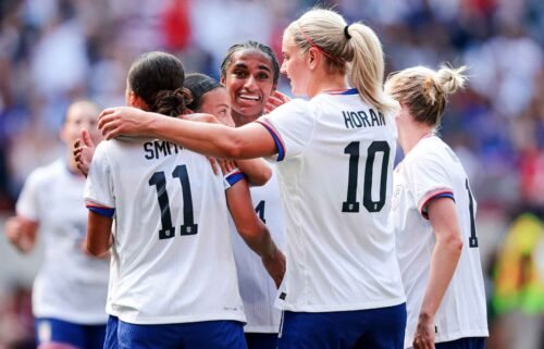 Players from the USWNT celebrate after scoring a goal.