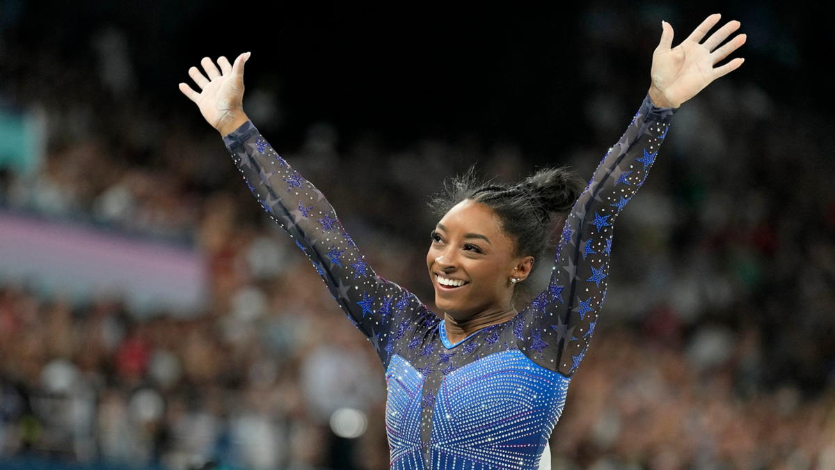 Simone Biles waves to the crowd after finishing her beam routine during the women's all-around final at the Paris 2024 Olympics.