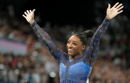 Simone Biles waves to the crowd after finishing her beam routine during the women's all-around final at the Paris 2024 Olympics.