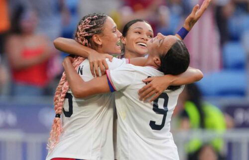 USWNT players celebrate after scoring a goal.