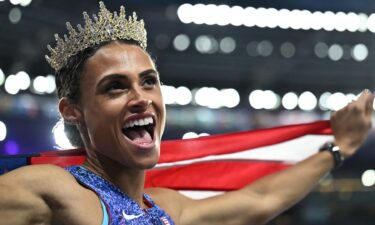 Gold medalist US' Sydney Mclaughlin-Levrone wears a crown as she celebrates winning the women's 400m hurdles final of the athletics event and setting a new world record during the Paris 2024 Olympic Games.