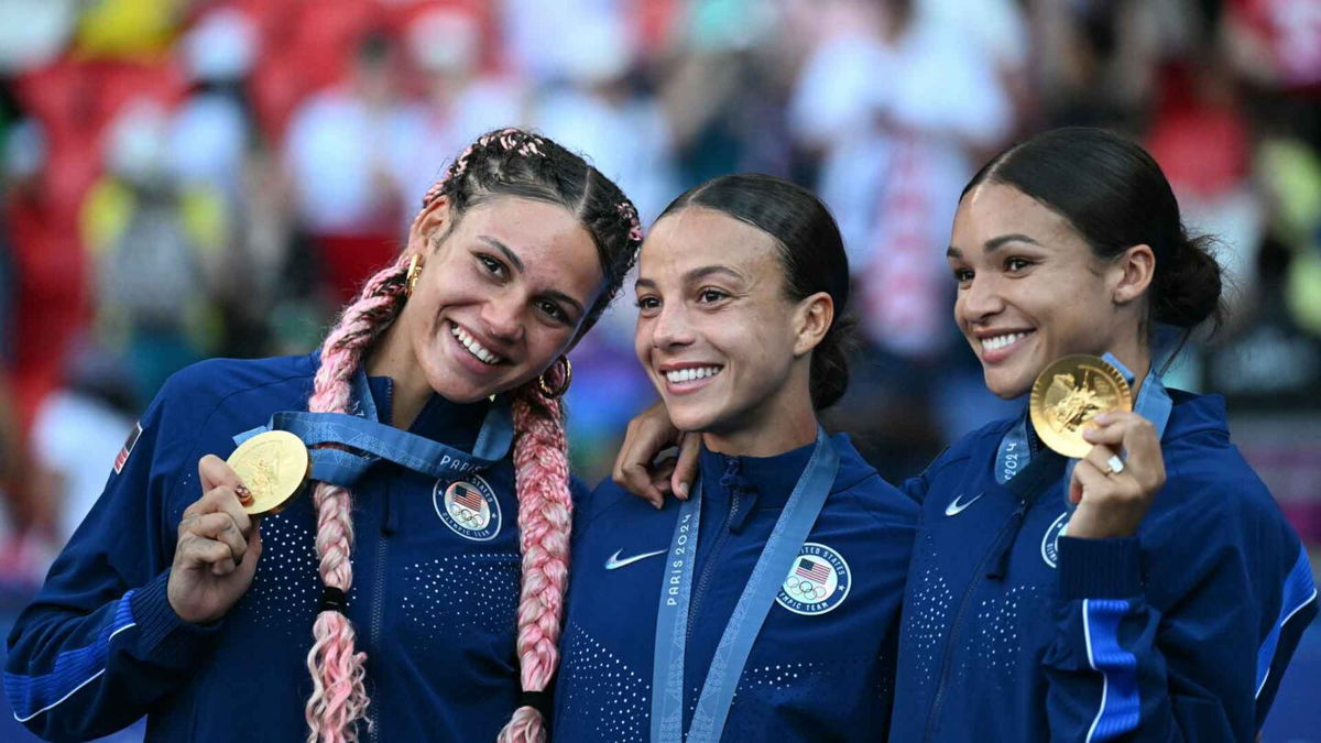 USWNT players pose with gold medals