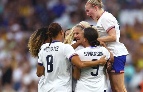 USWNT players celebrate after scoring a goal.