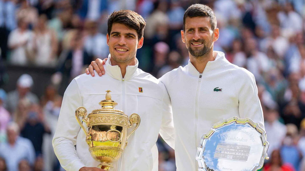 Carlos Alcaraz of Spain and Novak Djokovic of Serbia pose with their trophies after the men’s singles final on day 14 at All England Lawn Tennis and Croquet Club.