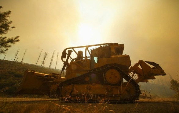 A dozer builds containment line to stop new growth on the human-caused Falls Fire, which has burned over 100,000 acres on the Malheur National Forest since early July.