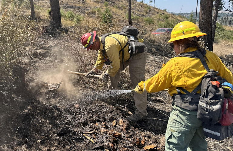Firefighters spray water and use hand tools during mop-up on the Durkee Fire.