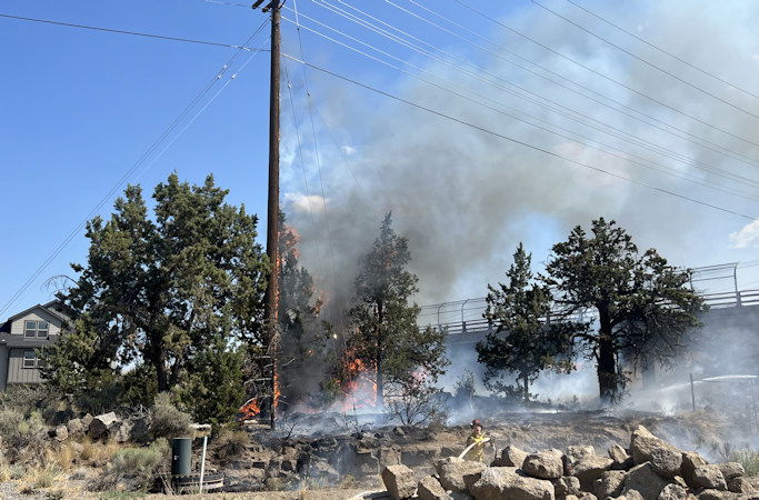 Firefighters extinguish quarter-acre fire next to Empire Avenue and Bend Parkway ramp; cause under investigation