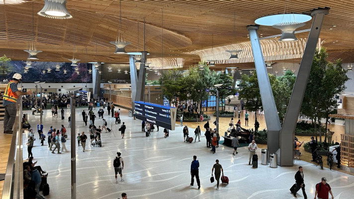 Travelers and visitors make their way through the new main terminal at Portland International Airport on its first day in operation.