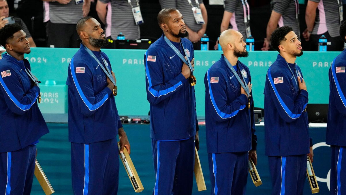 U.S. men's basketball team looks at U.S. flag during anthem at medal ceremony