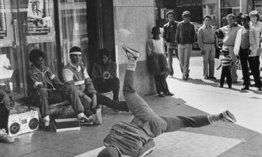 A crowd gathers to watch a youth breakdancing on a piece of linoleum in 1980 in New York City's Times Square.