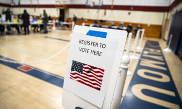 A sign to register to vote at a polling station inside Plymouth Elementary School in Plymouth