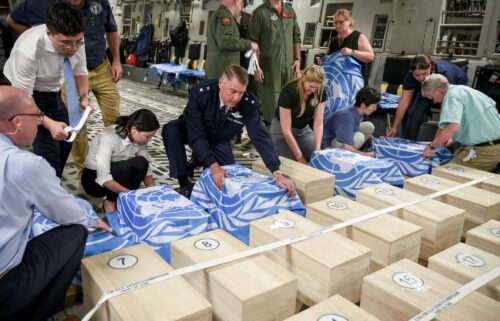 Crew and officials from the United Nations Command and U.S. Defense POW/MIA Accounting Agency (DPAA) secure UNC flags over transit cases of remains thought to be of U.S. soldiers killed in the 1950-53 Korean War