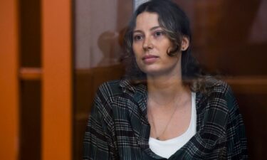 Ksenia Karelina sits in a glass cage in a court in Yekaterinburg