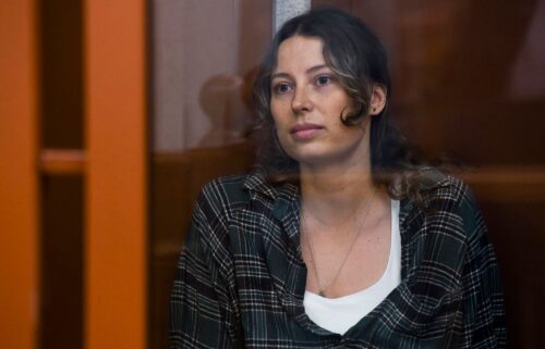 Ksenia Karelina sits in a glass cage in a court in Yekaterinburg