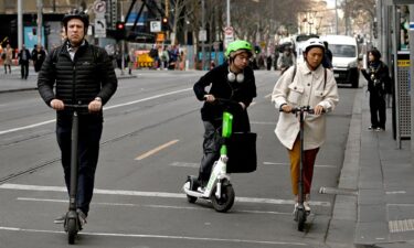 People ride e-scooters in Melbourne's central business district on August 14