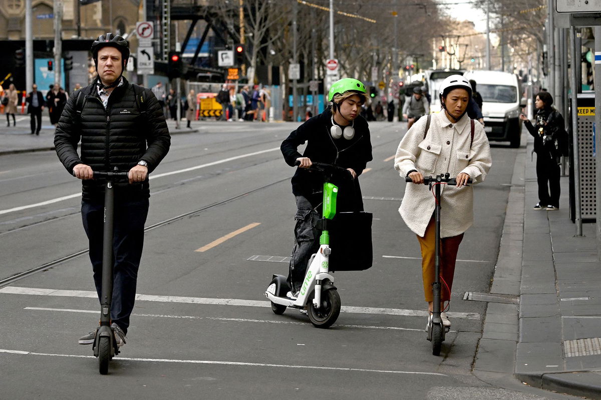 <i>William West/AFP/Getty Images via CNN Newsource</i><br/>People ride e-scooters in Melbourne's central business district on August 14