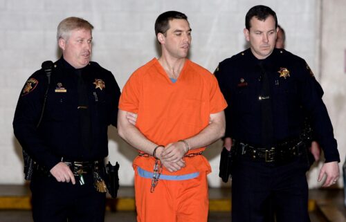 Convicted murderer Scott Peterson is escorted by two San Mateo County deputies as he is walked from the jail to an awaiting van March 17