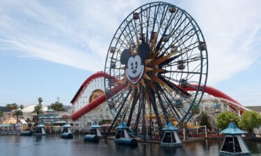 People ride on the Pixar Pal-A-Round ferris wheel in front of the Incredicoaster in the Disney California Adventure Park at Disneyland on April 11