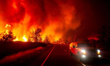 Smoke rises above the roadway as the Park Fire jumps Highway 36 near Paynes Creek in Tehama County