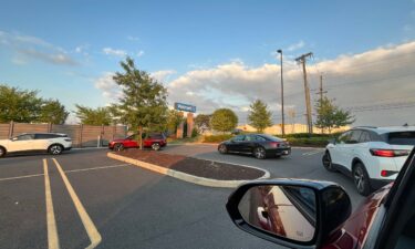 A line of EVs wait to charge at Electrify America chargers in East Brunswick