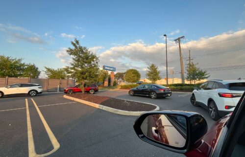 A line of EVs wait to charge at Electrify America chargers in East Brunswick