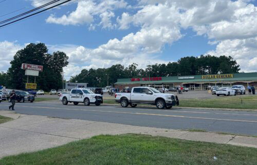 Police vehicles remain on the scene of a shooting at the Mad Butcher grocery store on June 21