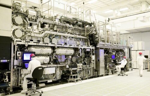 Workers are seen in front of a "High NA EUV" lithography system at an Intel facility in Hillsboro