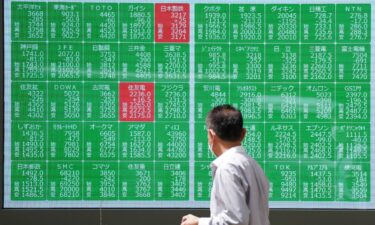 A man looks at an electronic board displaying stock prices in Tokyo on August 2.