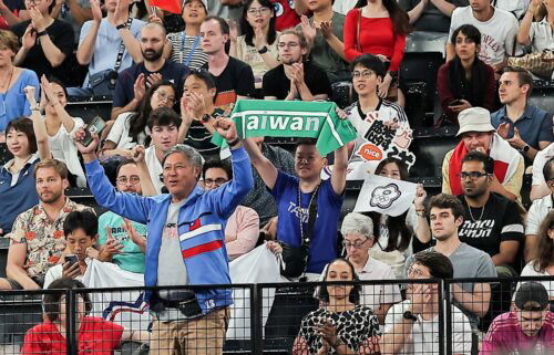 Journalists reported seeing a man holding a green Taiwan banner being removed from an Olympic badminton game mid-match.