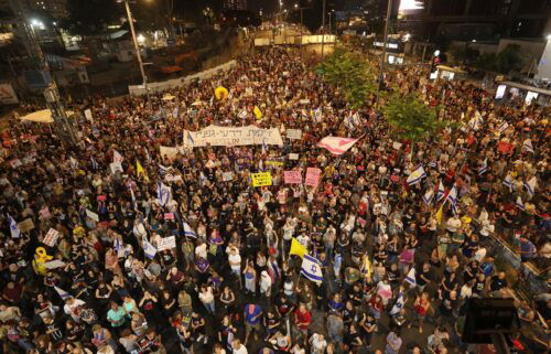 Supporters and relatives of Israelis held hostage by Palestinian militants in the Gaza Strip since October lift placards during a rally to demand their release in Tel Aviv on August 3.