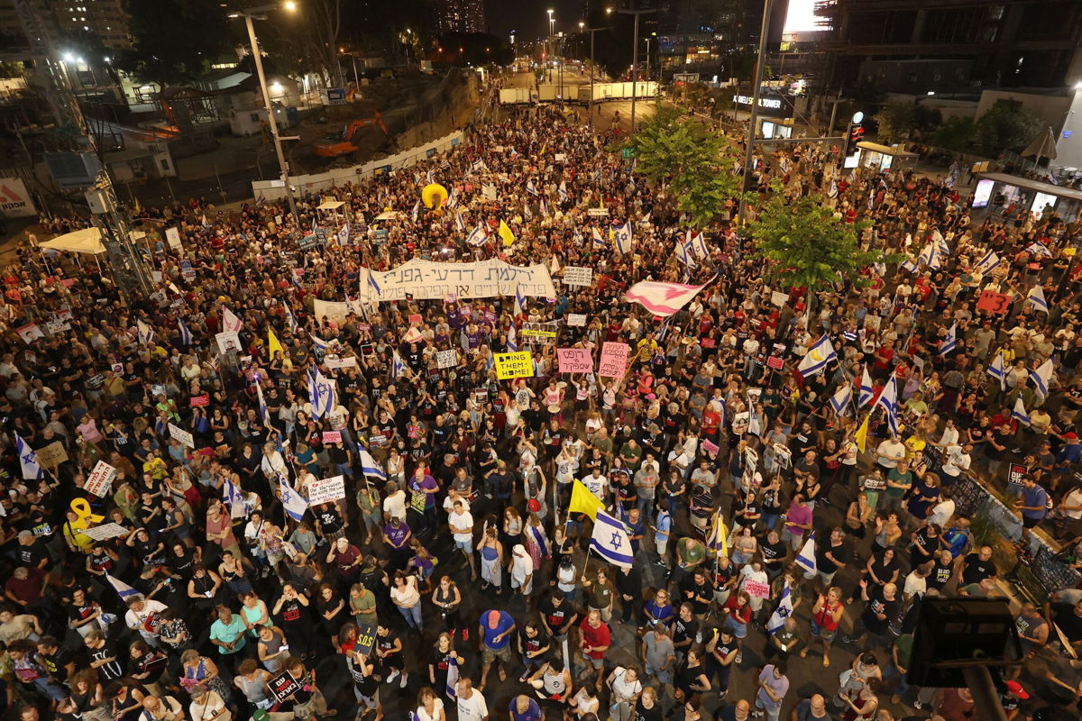 <i>Gil Cohen-Magen/AFP/Getty Images via CNN Newsource</i><br/>Supporters and relatives of Israelis held hostage by Palestinian militants in the Gaza Strip since October lift placards during a rally to demand their release in Tel Aviv on August 3.