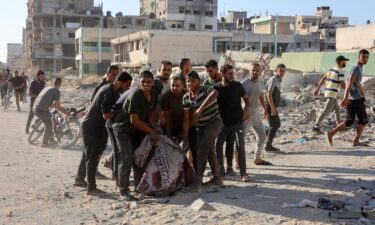 Palestinians evacuate a body pulled from the rubble following Israeli bombardment which hit a school complex