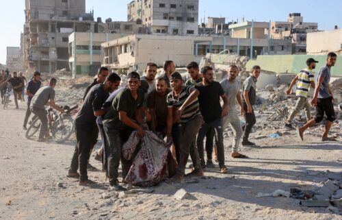 Palestinians evacuate a body pulled from the rubble following Israeli bombardment which hit a school complex