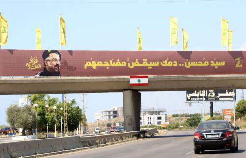 Hezbollah flags are erected along with a banner showing assassinated Hezbollah commander Fuad Shukr in southern Lebanon.