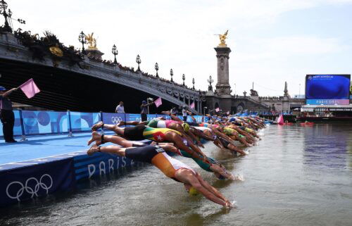 Athletes dive into the River Seine to start the swimming stage of the men's individual triathlon at the Paris 2024 Olympic Games on July 31.