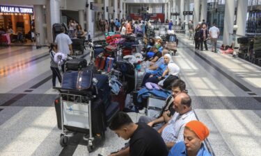 People await their flights at the Beirut airport's departure hall as urgent calls grew for foreign nationals to leave Lebanon