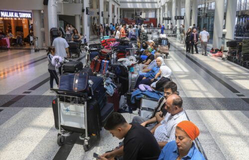 People await their flights at the Beirut airport's departure hall as urgent calls grew for foreign nationals to leave Lebanon