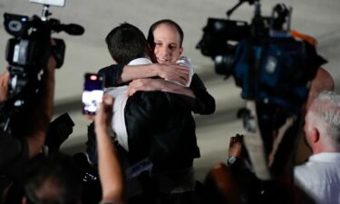 Reporter Evan Gershkovich receives an embrace following his release as part of a 24-person prisoner swap between Russia and the United States on Thursday