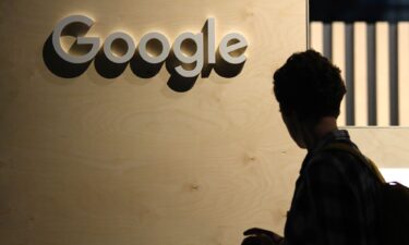 A woman passes the logo from the web search engine provider Google during the digital society festival 're:publica