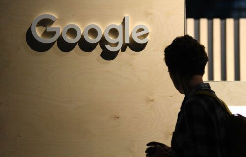 A woman passes the logo from the web search engine provider Google during the digital society festival 're:publica