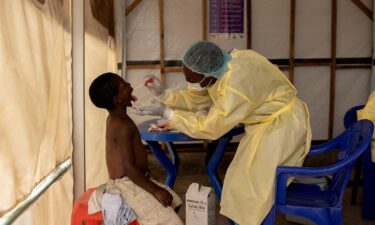 A nurse takes a sample from a child suspected of having mpox at a treatment centre in Munigi