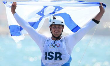 Israel's Tom Reuveny celebrates winning the gold in men's windsurf iQFoil class final at Marseille Marina on August 3.