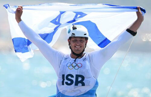 Israel's Tom Reuveny celebrates winning the gold in men's windsurf iQFoil class final at Marseille Marina on August 3.