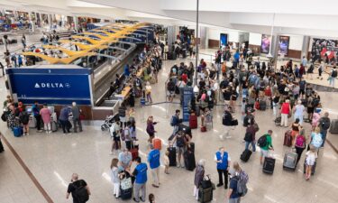 Delta Airlines passengers line up for agent assistance at Hartsfield-Jackson Atlanta International Airport on July 22