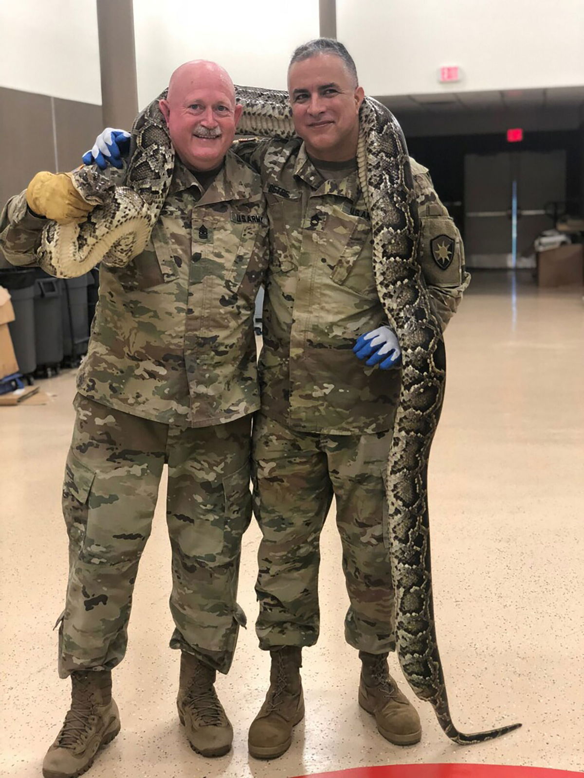 <i>Courtesy Thomas H. Aycock via CNN Newsource</i><br/>Aycock and soldier Joe Detre holding a 14-foot python captured by Aycock.