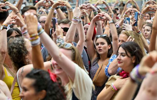 Fans of the singer Taylor Swift make a heart shape with their hands as they gather following the cancellation of three Taylor Swift concerts at Happel stadium after the government confirmed a planned attack at the venue