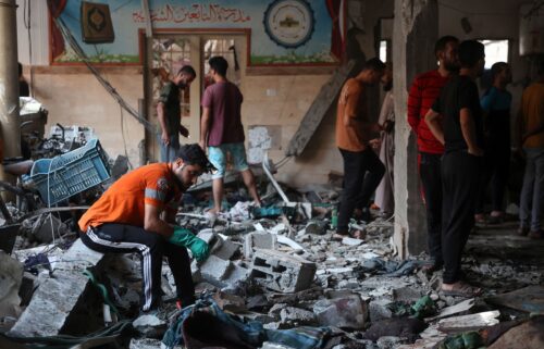 People check the damage inside a school being used as a temporary shelter for displaced Palestinians